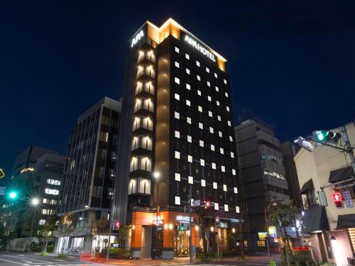 un edificio alto con luces encima en APA Hotel Ginza Shintomicho Ekimae Kita, en Tokio