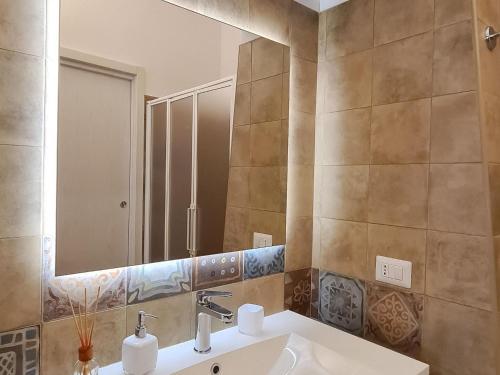 W łazience znajduje się umywalka i lustro. w obiekcie Beautiful trulli property with annex in Locorotondo w mieście Locorotondo