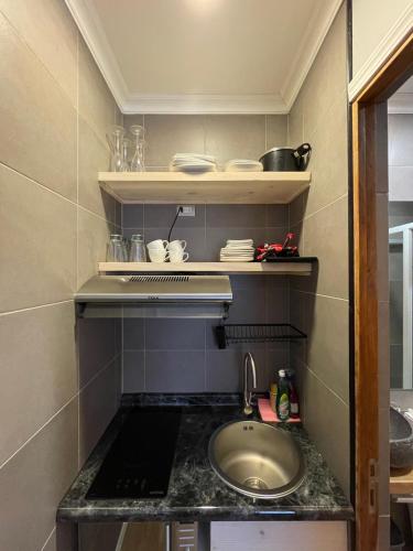 a small kitchen with a sink and a counter at Hostal Boutique Puerta Roja in Punta Arenas