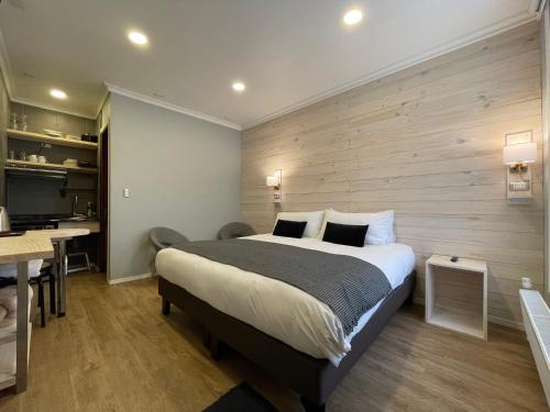 a bedroom with a bed and a desk and a kitchen at Hostal Boutique Puerta Roja in Punta Arenas