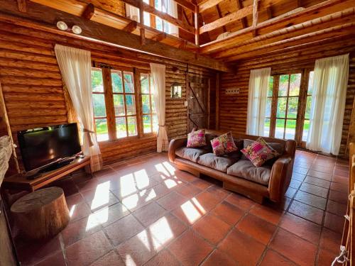 sala de estar con sofá y TV de pantalla plana en Casa Estilo Cabaña, Bosque Peralta Ramos en Mar del Plata