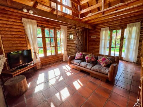 a living room with a couch and a flat screen tv at Casa Estilo Cabaña, Bosque Peralta Ramos in Mar del Plata