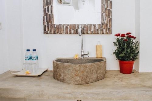 La salle de bains est pourvue d'un lavabo en béton sur un comptoir. dans l'établissement Govardan Home stay, à Canggu