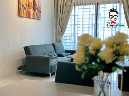 クチンにあるStaycation Homestay 12 Liberty Grove Near Airportのリビングルーム(ソファ、花瓶付)