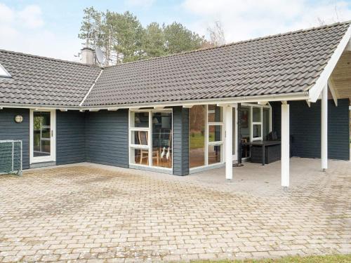 a blue house with a roof and a patio at 10 person holiday home in R dby in Rødby