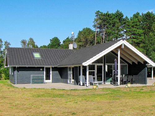 una casa negra con techo de gambrel en 10 person holiday home in R dby en Rødby