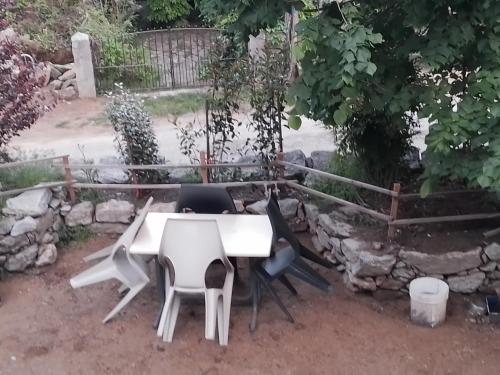 un tavolo bianco e sedie in un cortile di Maison de caractère au coeur de la corse rurale a Calacuccia