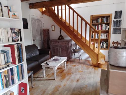 a living room with a staircase and a couch and a table at Maison de caractère au coeur de la corse rurale in Calacuccia