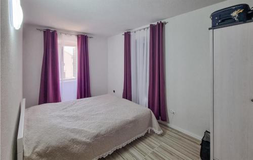 1 dormitorio con 1 cama con cortinas moradas y ventana en Nice Apartment In Funtana With Kitchen, en Funtana