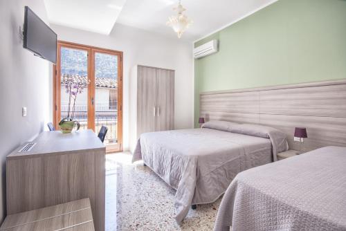 a bedroom with two beds and a flat screen tv at B&B La Torre in Castellammare del Golfo