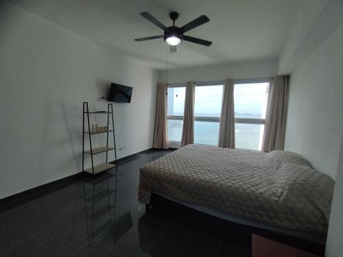 1 dormitorio con 1 cama y ventilador de techo en Grand Bay Tower, en Panamá