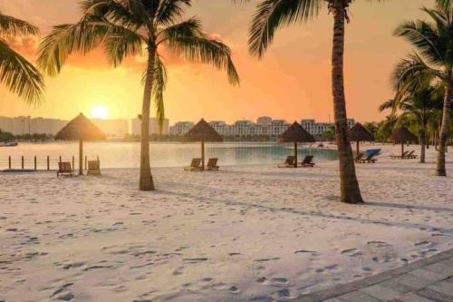 uma praia com palmeiras e um pôr-do-sol em Blue Ocean Homestay em Hanói