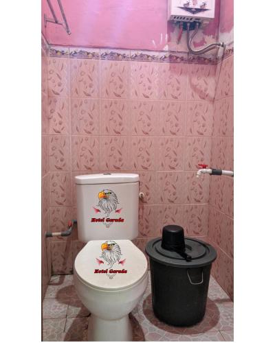 baño con aseo y cubo de basura en Hotel Garuda en Rambah