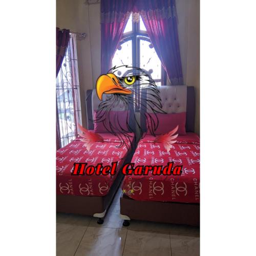 an eagle sitting on a bed in a room at Hotel Garuda in Rambah