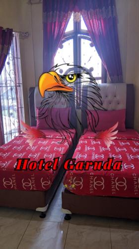 una pintura de un águila en una cama en una habitación en Hotel Garuda en Rambah