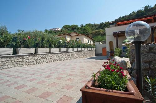 a street light with flowers in a planter next to a building at Le Casette Sul Mare in Capo Vaticano