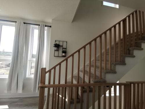 Una escalera en una casa con ventana en Beautiful, 4brd-3bthTownhome 7mins to Lakeshore, en Barrie