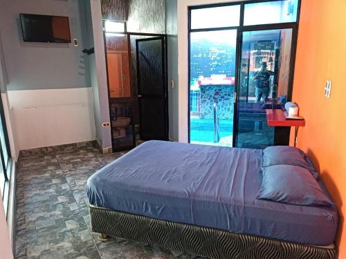 a bedroom with a bed and a large window at Hospedaje Vegas in Tarapoto