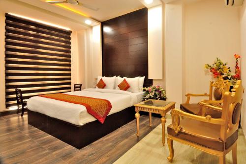 una habitación de hotel con una cama y una silla en Hotel Kings Inn, Karol Bagh, New Delhi, en Nueva Delhi