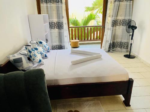 a bed in a room with a window at Beachfront Studio-Waves & Wanderlust Haven in Mombasa