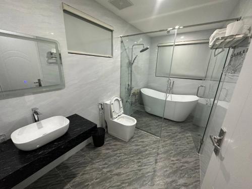La salle de bains est pourvue d'un lavabo, d'une baignoire et de toilettes. dans l'établissement Lavender Sonasea Vân Đồn, Quảng Ninh, à Quảng Ninh