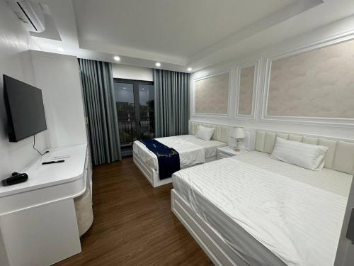 Habitación de hotel con 2 camas y TV en Lavender Sonasea Vân Đồn, Quảng Ninh en Quang Ninh