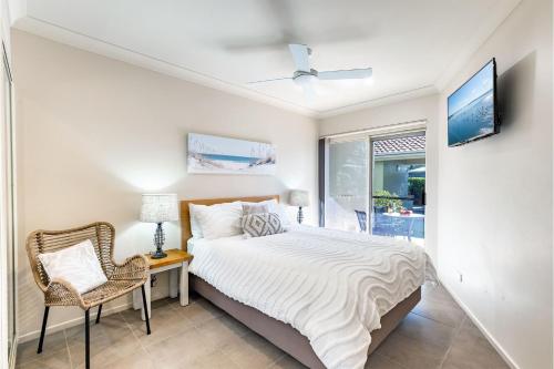una camera da letto con un letto, una sedia e una finestra di Martys 7 2 Intrepid Cl - pool , air con , Wi-Fi and linen a Nelson Bay