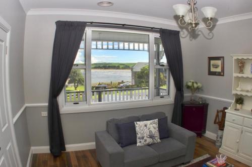 a living room with a couch and a large window at Number 10 -King bed with breakfast in Stanley
