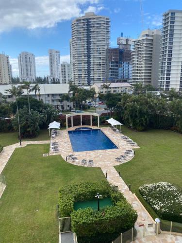 a swimming pool in a park with tall buildings at Contessa Holiday Apartments in Gold Coast