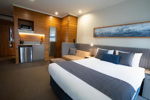 a hotel room with a large bed and a kitchen at Sovereign Park Motor Inn in Ballarat