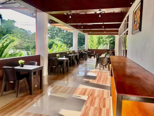 un restaurant avec des tables et des chaises ainsi qu'un bar dans l'établissement Frachette's Bed & Breakfast, à Puerto Princesa