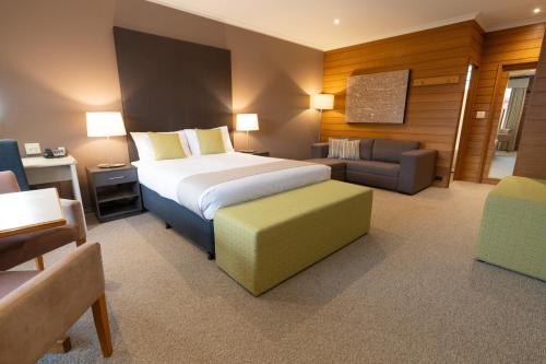 a hotel room with a bed and a couch at Sovereign Park Motor Inn in Ballarat