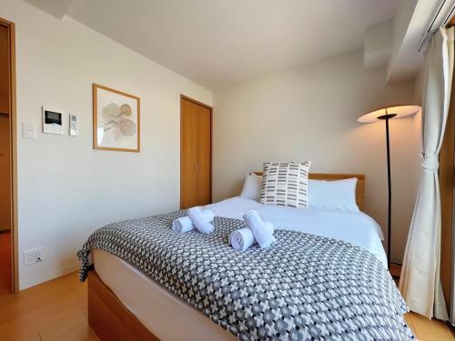 a bedroom with a bed with two teddy bears on it at NALY. TENMA AFP Apartment in Osaka