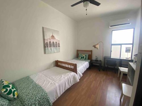 1 dormitorio con 2 camas, escritorio y ventana en Departamento en SLRC, en San Luis Río Colorado