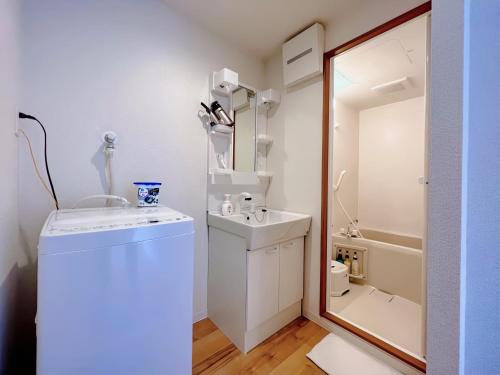 a small bathroom with a sink and a mirror at NALY. TENMA AFP Apartment in Osaka