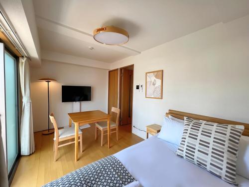 a bedroom with a bed and a desk and a table at NALY. TENMA AFP Apartment in Osaka