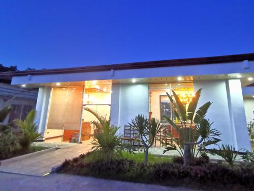 una casa blanca con un cielo azul en E&R Airport Hotel, en Dumaguete
