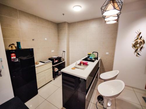 a small kitchen with a black refrigerator and a sink at Studio suite nearby Lost World of Tambun in Tambun