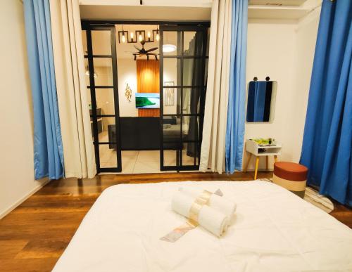a bedroom with a large white bed with blue curtains at Studio suite nearby Lost World of Tambun in Tambun