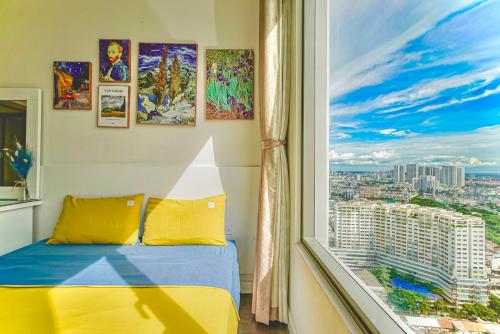 a bedroom with a view of a city from a window at RiverGate Residence Apartment - The Origin in Ho Chi Minh City