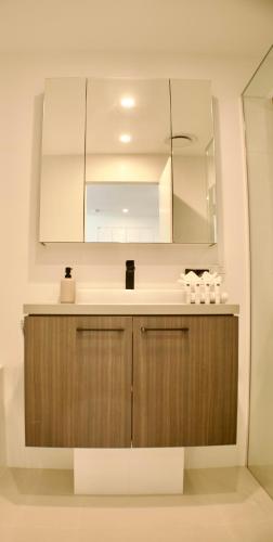 a bathroom with a sink and a mirror at COASTAL ESCAPE@ The Cosmopolitan Unit 20806 in Maroochydore