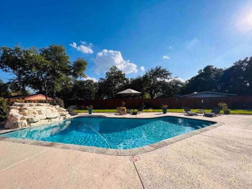a swimming pool in a backyard with chairs around it at *New* Casa Azul-4B4B Upscale Oasis-Pool in San Antonio