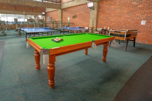 a ping pong table in a room with several tables at Sovereign Park Motor Inn in Ballarat