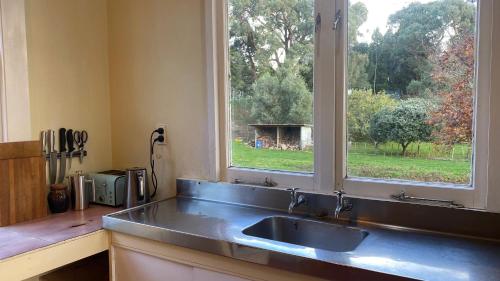 cocina con fregadero de acero inoxidable y ventana en Rustic Cottage Farm Stay en Brunswick