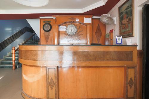 a wooden bar with a clock on top of it at Super Collection O 1064 Tipsyy Inn Suites 17 in Sohna