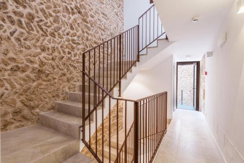 a staircase in a house with a stone wall at Bordoy Mostatxins - Hotel Boutique Adults Only in Alcudia