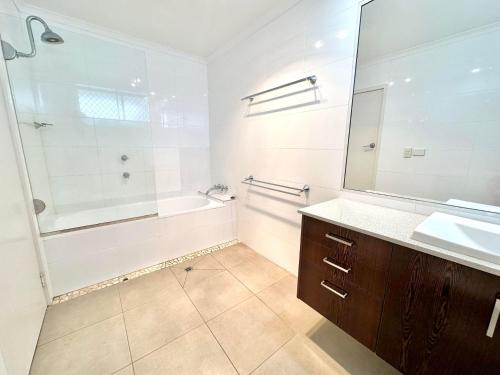 a bathroom with a tub and a sink and a shower at Craigmore Penthouse in Yamba