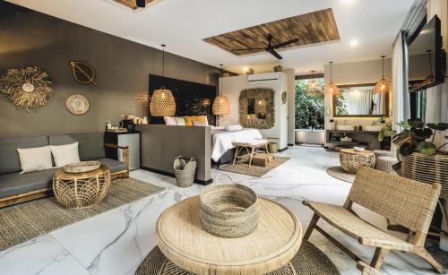 a living room with a bed and a table and chairs at Namu Garden Hotel & Spa - Adults Only in Puerto Viejo