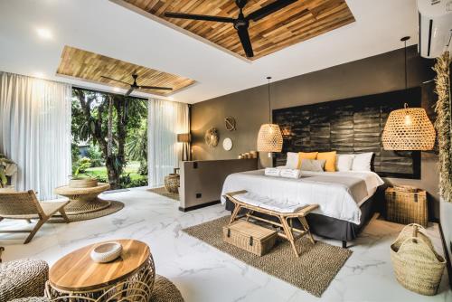 a bedroom with a bed and a table and chairs at Namu Garden Hotel & Spa in Puerto Viejo