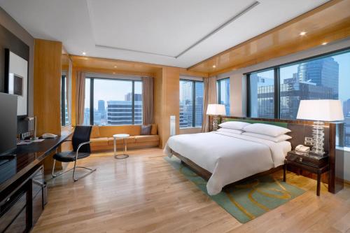 a bedroom with a bed and a desk and a couch at Renaissance Bangkok Ratchaprasong Hotel in Bangkok